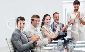 Business people applauding a colleague after reporting to sales