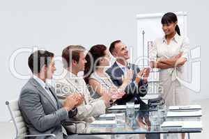 Business people applauding a colleague after reporting to sales