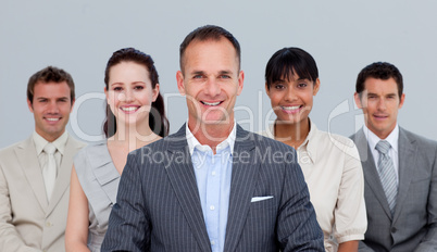 Smiling multi-ethnic business team standing in front of the came