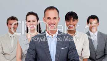 Smiling multi-ethnic business team standing in front of the came