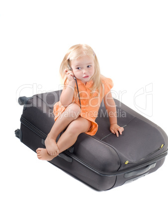 Little girl and suitcase in studio