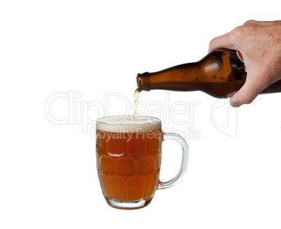 Beer being poured from bottle into pint