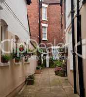 Narrow alley leading to red brick house