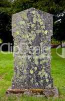 Old grave marker with lichen and moss