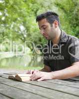 Man reading beside a canal