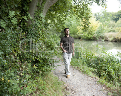 Man walking along a canal path.