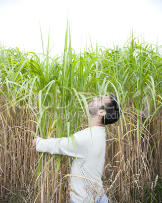Man hugging a crop of bamboo.