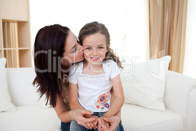 Attentive mother kissing her little girl