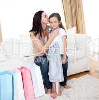 Mother kissing her little girl after shopping