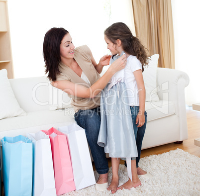 Portrait of a mother and her daughter trying on a dress