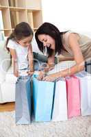 Happy Mother and daughter unpacking shopping bags