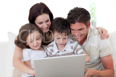 Family using a laptop on the sofa