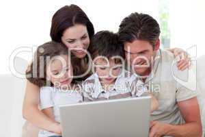 Family using a laptop on the sofa