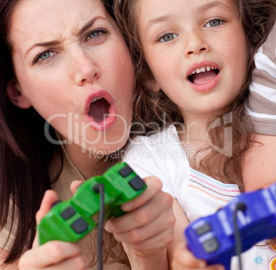 Excited mother and her daughter playing video games