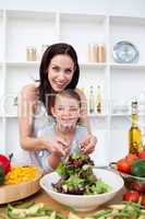 Happy mother and her girl preparing a salad