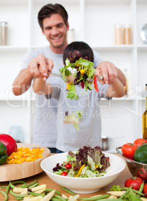 Happy father and his son preparing a salad