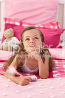 Portrait of a little girl lying on bed