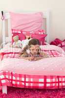 Little girl writing on bed