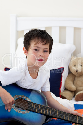 Portrait of a little boy playing guitar