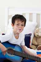 Portrait of a little boy playing guitar