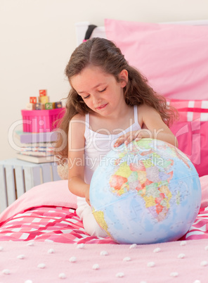 Little girl having fun with a terrestrial globe