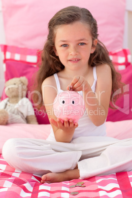 Little girl saving money in a piggybank