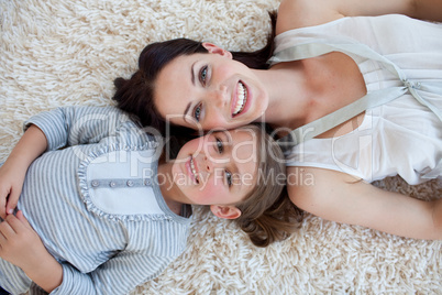Happy mother and her girl lying on the floor