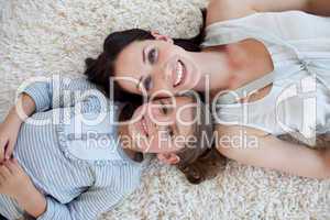 Happy mother and her girl lying on the floor