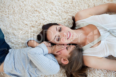 Smiling mother and her daughter lying on the floor