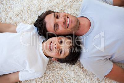 Smiling Father and his son lying on the floor