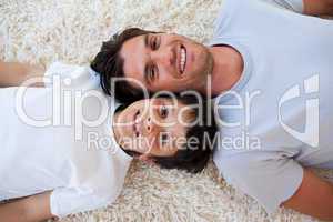 Smiling Father and his son lying on the floor