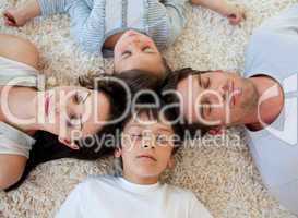 Family sleeping on the floor with heads together