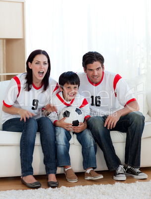 Parents and their son watching a football match