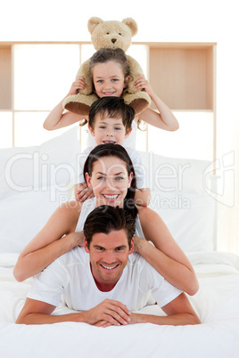 Young Family playing on bed together