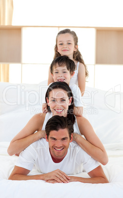 Family having fun on parent's bed
