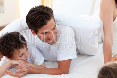Father and his son having fun on bed