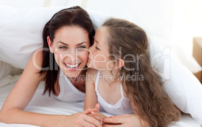 Mother and her daughter having fun on bed