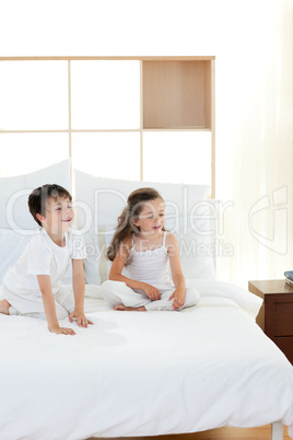 Brother and sister having fun in parent's bedroom