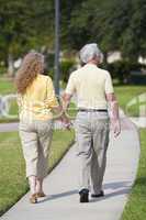Rear View Senior Man and Woman Couple Walking Holding Hands