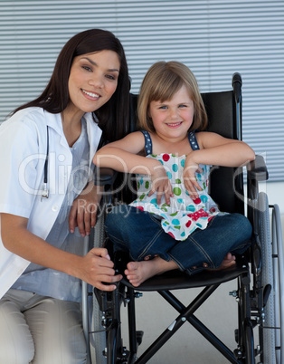 Cute girl sitting on a wheelchair with a female doctor