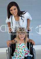 Portrait of a little girl on a wheelchair and a young doctor