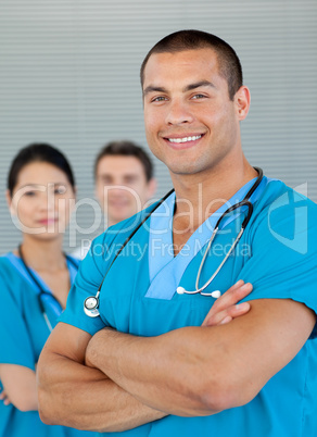 Portrait of an attractive doctor with his colleagues in the back