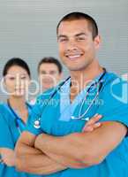 Portrait of an attractive doctor with his colleagues in the back