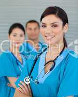Attractive female doctor with his colleagues in the background