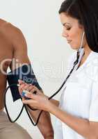 Close-up of a female doctor checking the blood pressure of a pat