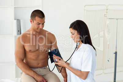 Confident female doctor checking the blood pressure of a patient