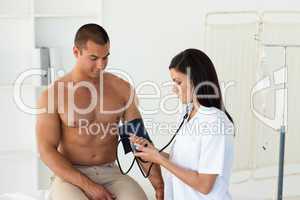 Confident female doctor checking the blood pressure of a patient