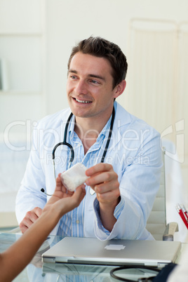 A doctor giving pills to his patient