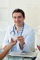 Smiling doctor giving pills to his patient