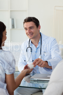Male doctor giving pills to a female patient
